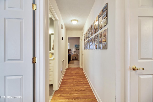 hallway with hardwood / wood-style flooring