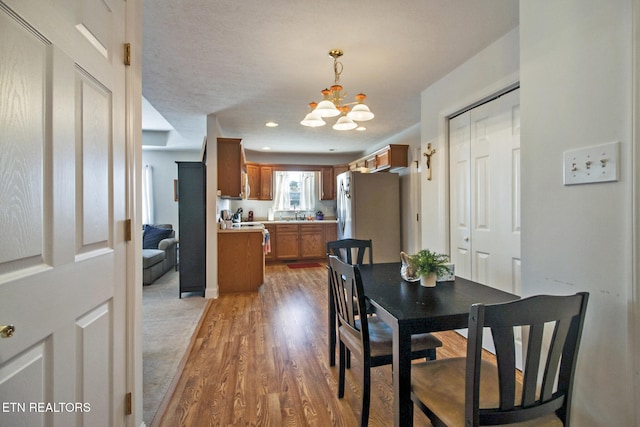 dining room with wood-type flooring and an inviting chandelier