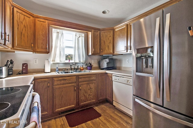 kitchen with sink, dishwasher, electric range oven, dark wood-type flooring, and stainless steel fridge with ice dispenser