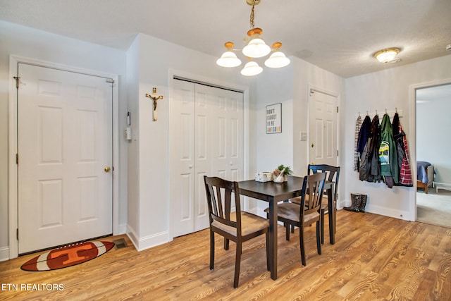 dining space featuring light hardwood / wood-style floors and a notable chandelier