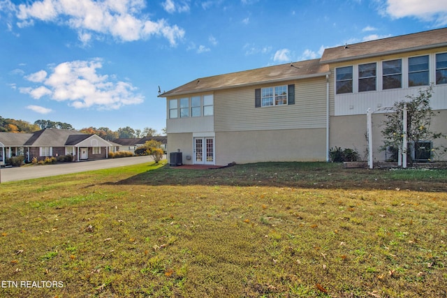 back of property with french doors, a yard, and cooling unit