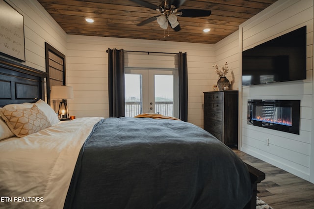 bedroom with wood walls, wooden ceiling, hardwood / wood-style floors, and access to exterior