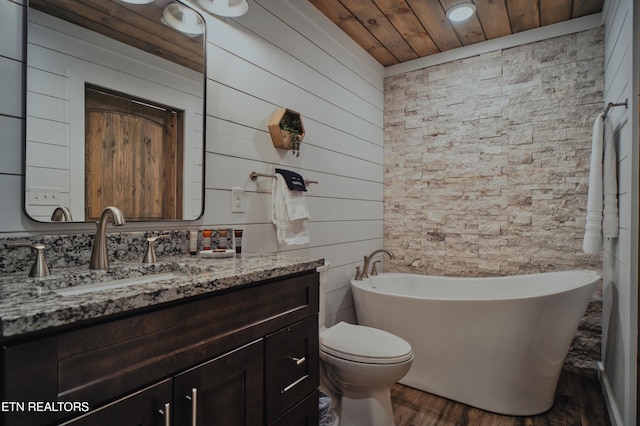 bathroom with wood walls, a washtub, toilet, wooden ceiling, and vanity