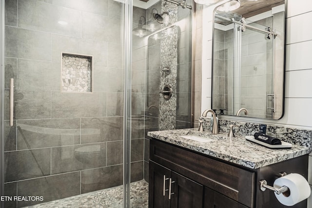 bathroom with vanity and a shower with door