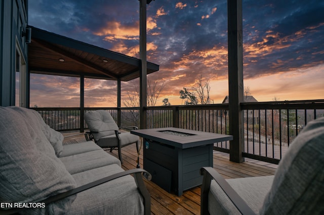 deck at dusk with an outdoor living space with a fire pit