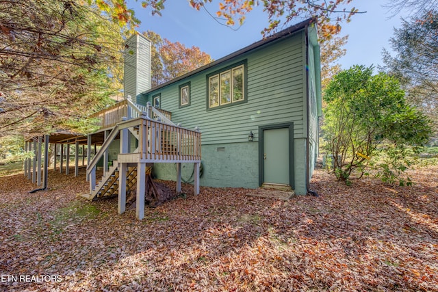 rear view of property featuring a wooden deck