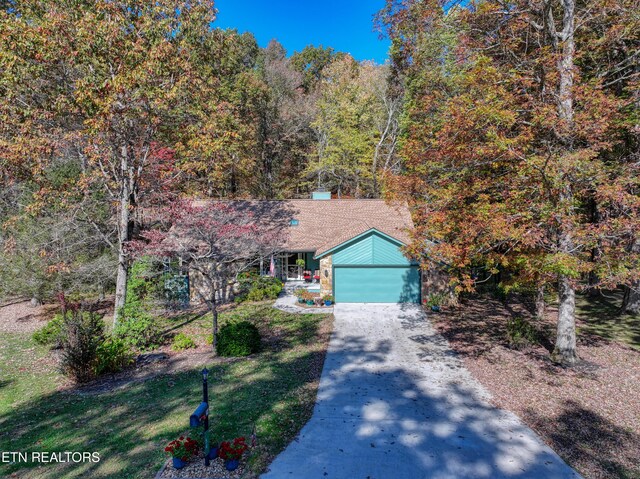 54 Heather Glen Ct, Crossville, TN 38558 - view of front of home featuring driveway, an attached garage, and a wooded view