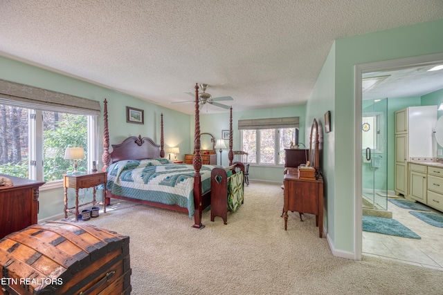 carpeted bedroom featuring a textured ceiling, ensuite bath, and ceiling fan