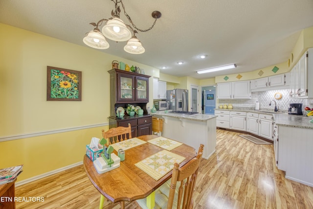 54 Heather Glen Ct, Crossville, TN 38558 - dining room featuring light wood-style flooring, a textured ceiling, and baseboards