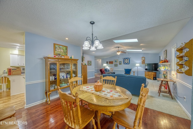 54 Heather Glen Ct, Crossville, TN 38558 - dining space featuring light wood-style floors, a skylight, a chandelier, lofted ceiling, and a ceiling fan