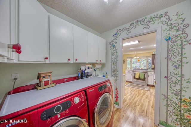 washroom featuring light hardwood / wood-style flooring, independent washer and dryer, a textured ceiling, and cabinets