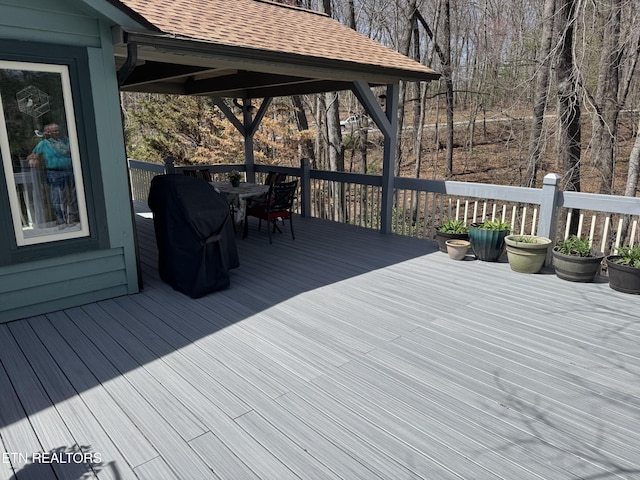 wooden terrace with grilling area and outdoor dining space
