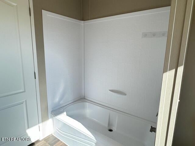 bathroom featuring tiled shower / bath combo and hardwood / wood-style floors