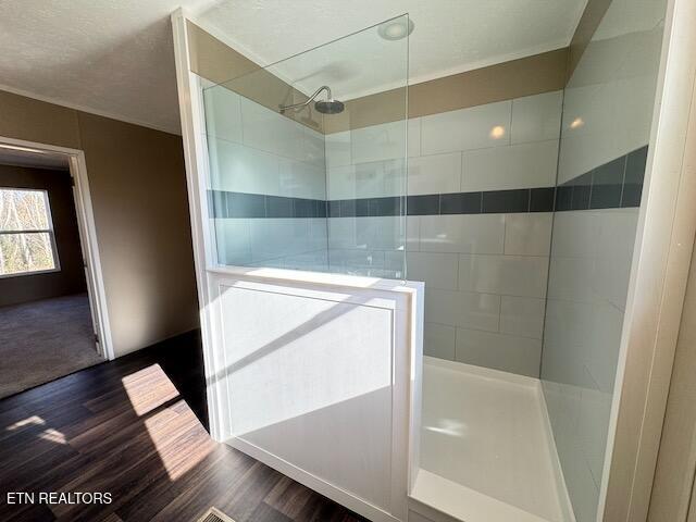 bathroom with hardwood / wood-style floors and tiled shower