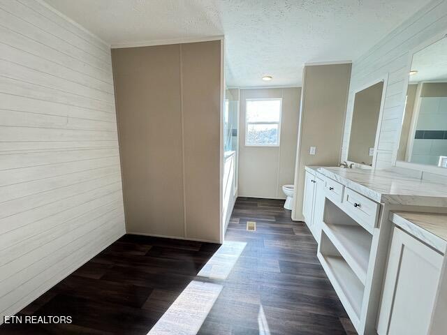 bathroom with vanity, toilet, a textured ceiling, and hardwood / wood-style floors