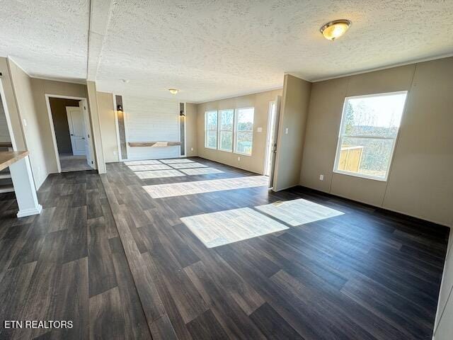 unfurnished living room with dark wood-type flooring and a textured ceiling