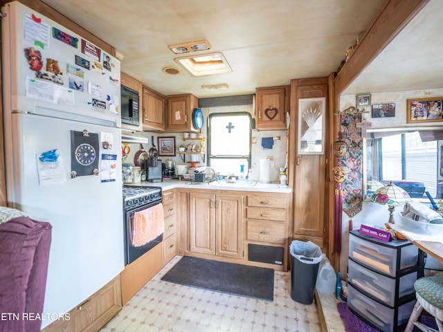 kitchen with black gas stove and white fridge