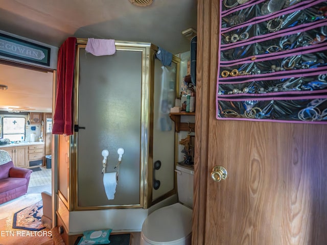 bathroom featuring toilet and walk in shower