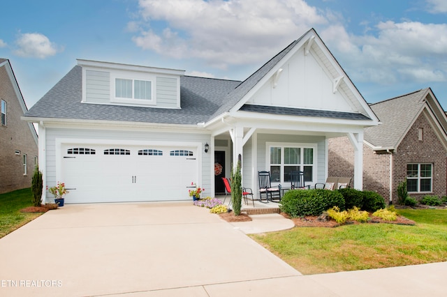 view of front facade with covered porch, a garage, and a front yard