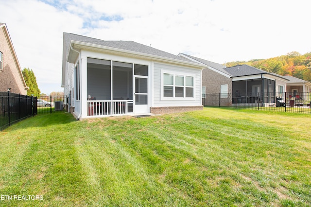 rear view of property with a yard and a sunroom