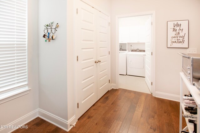 hallway featuring wood-type flooring and washing machine and dryer