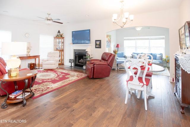 living room with dark wood-type flooring and ceiling fan with notable chandelier