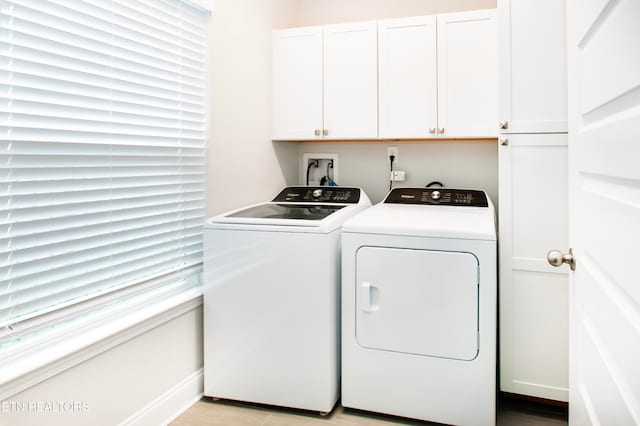 laundry area with washing machine and dryer and cabinets