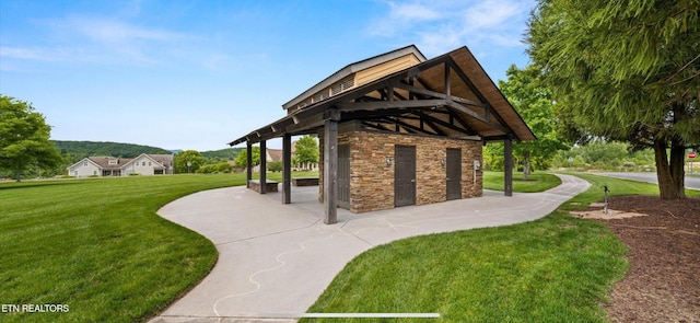 view of property's community featuring a yard and a patio