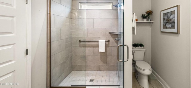 bathroom with toilet and a shower with shower door