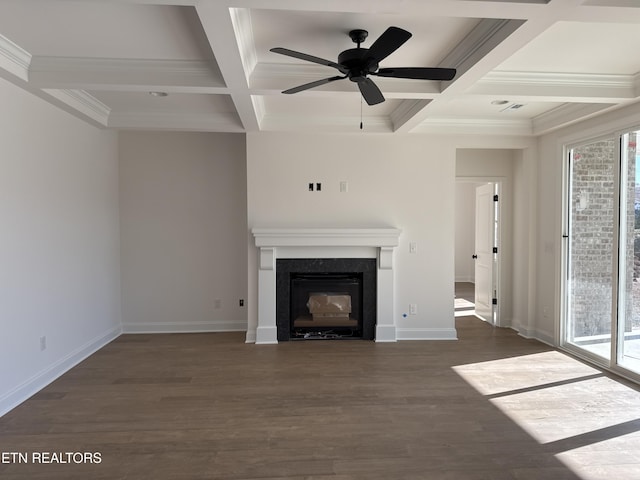 unfurnished living room with dark wood finished floors, a glass covered fireplace, and plenty of natural light