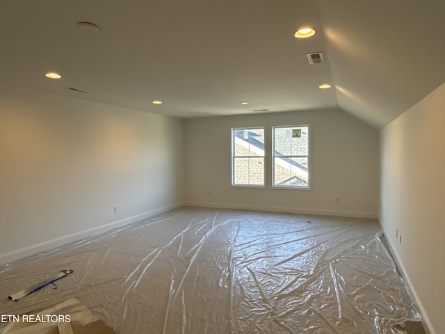 unfurnished room with lofted ceiling, baseboards, visible vents, and recessed lighting