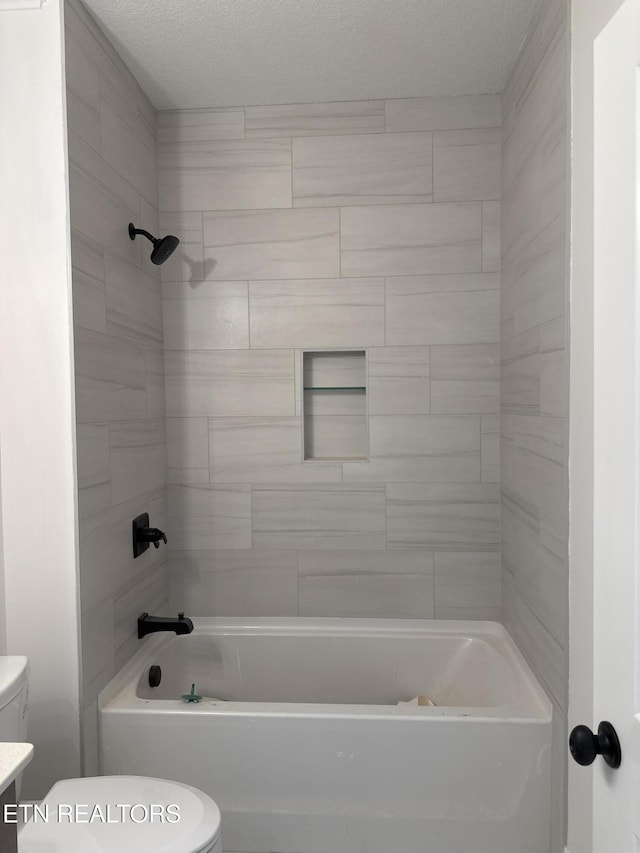 full bath with toilet, shower / tub combination, and a textured ceiling