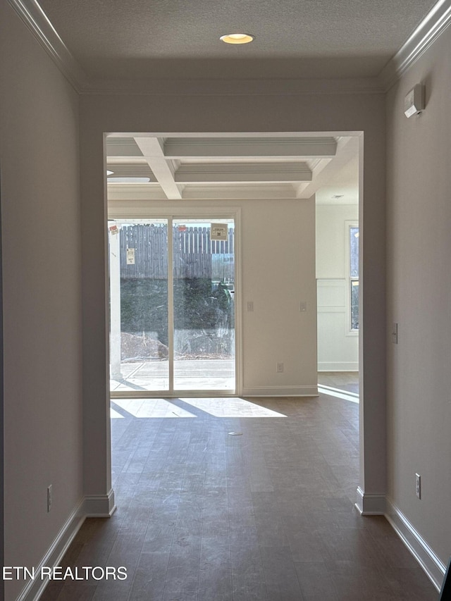 empty room with a textured ceiling, coffered ceiling, beam ceiling, and crown molding