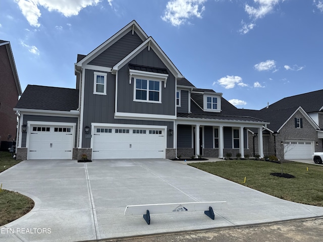 craftsman inspired home with concrete driveway, metal roof, a standing seam roof, board and batten siding, and a front yard