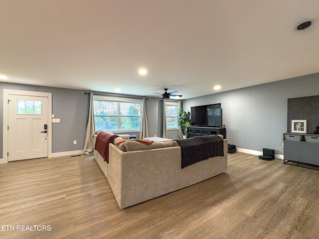 living room with light wood-type flooring and ceiling fan