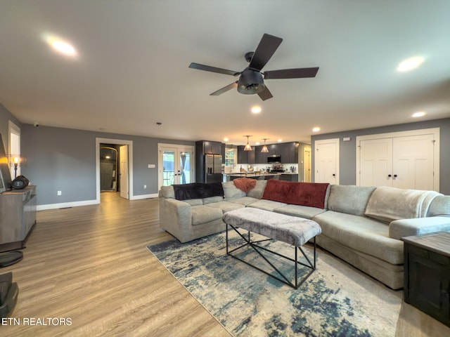 living room featuring hardwood / wood-style floors, ceiling fan, and french doors