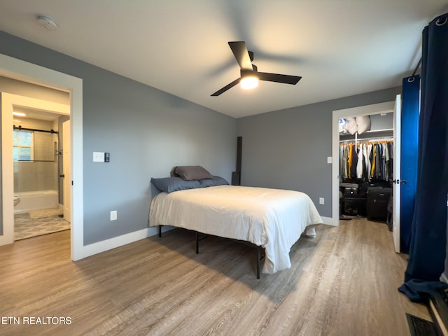 bedroom with hardwood / wood-style floors, ceiling fan, a closet, and a walk in closet