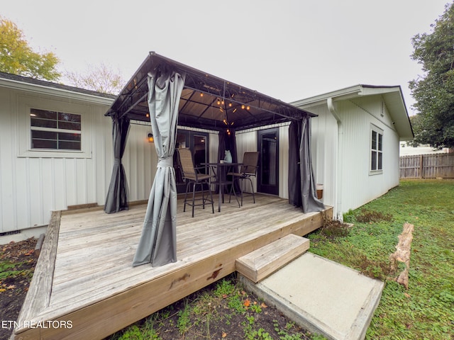 wooden deck featuring a yard and a gazebo