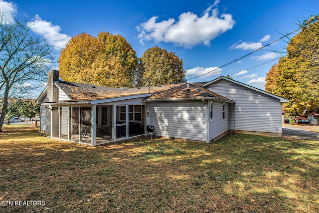 rear view of house with a sunroom and a yard