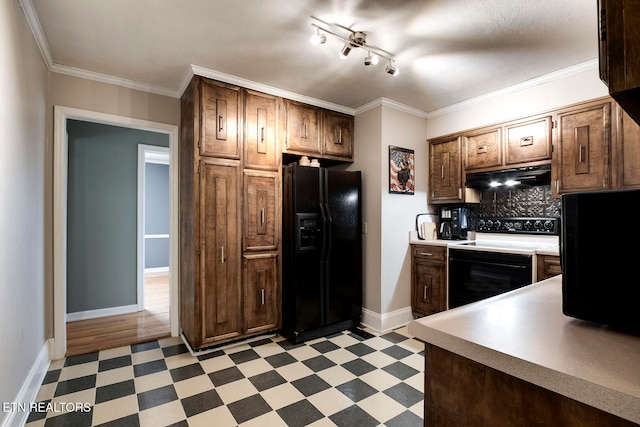 kitchen featuring ornamental molding, decorative backsplash, black fridge, and electric range