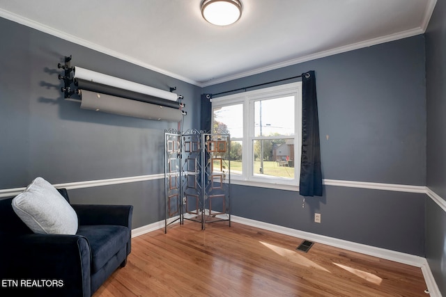 sitting room featuring wood-type flooring and ornamental molding