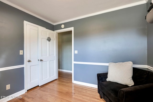 living area featuring light wood-type flooring and crown molding