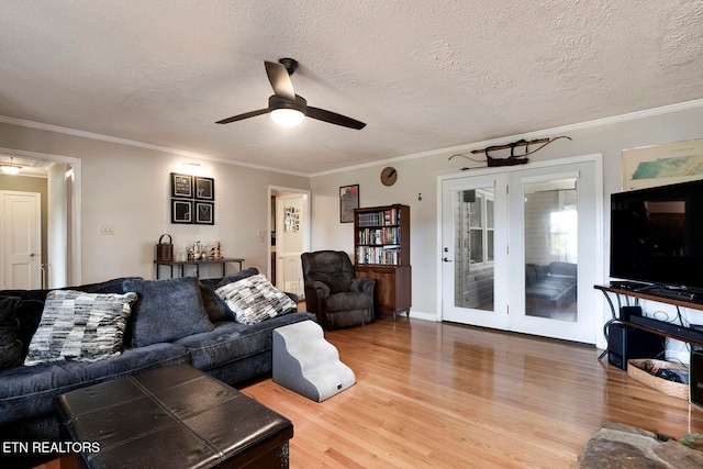 living room featuring ceiling fan, wood-type flooring, crown molding, and a textured ceiling