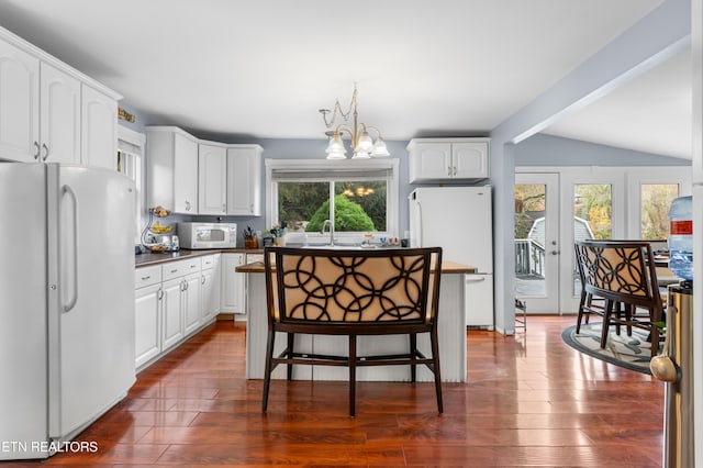 kitchen with a wealth of natural light, white cabinetry, and white appliances