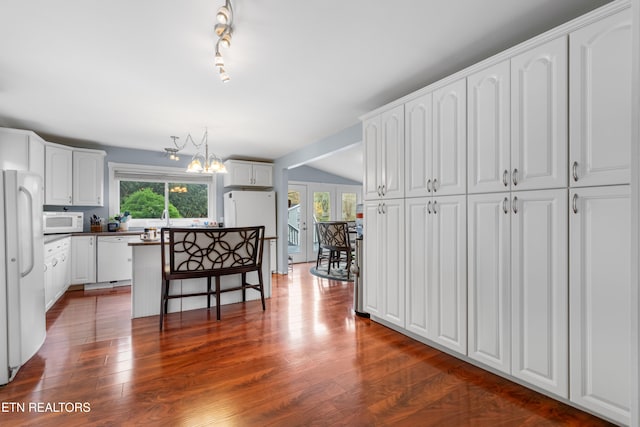 kitchen with vaulted ceiling, a notable chandelier, white cabinetry, white appliances, and dark hardwood / wood-style flooring