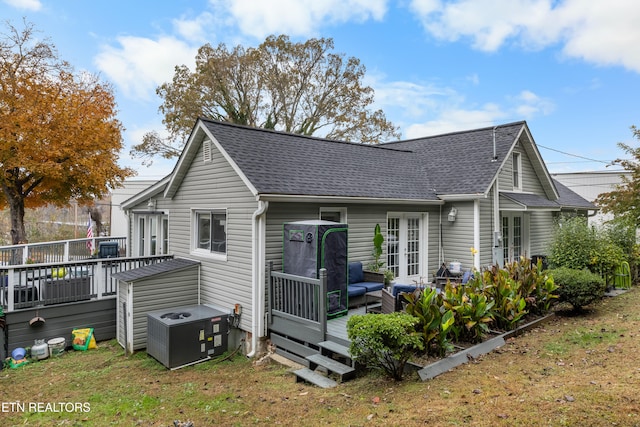 rear view of property with a yard, a deck, and central AC unit