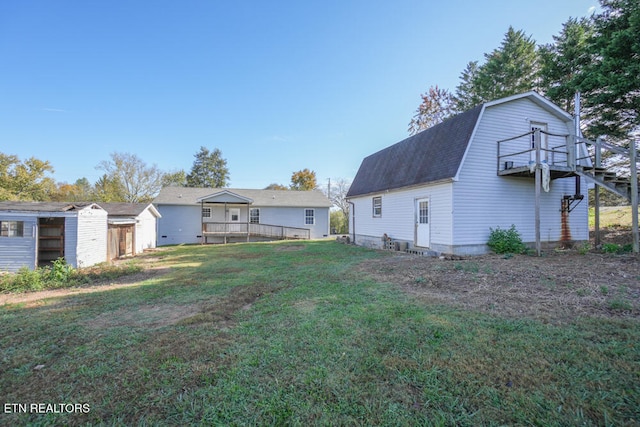 back of house featuring a wooden deck and a yard