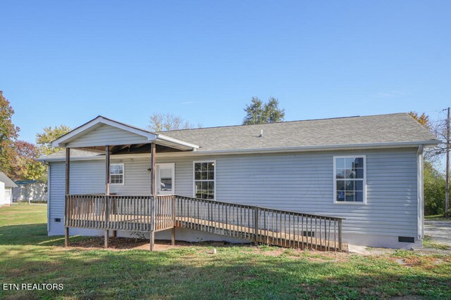 rear view of property with a deck and a lawn