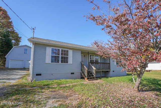 view of front of property featuring a front yard, an outdoor structure, and a garage