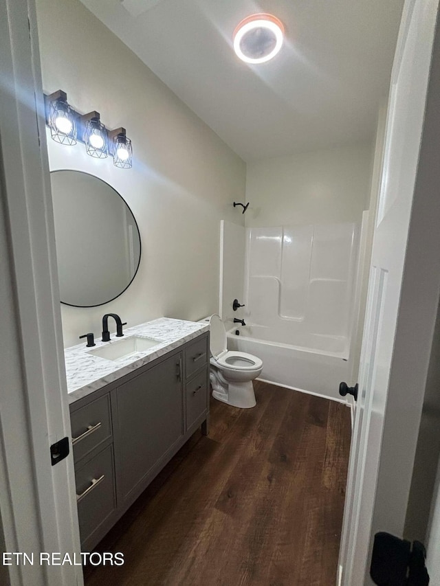 full bathroom featuring vanity, toilet, wood-type flooring, and bathing tub / shower combination